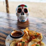 Mexico Travel Tips: Culture, Cuisine & Coastlines in One Trip "My messy plate of tacos meets Day of the Dead vibes on a Mexican beach."