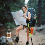 Planning Your First Solo Adventure? Here’s a Complete Guide Consider these elements: a solo hiker pausing mid-trail with a slightly oversized backpack and a crumpled national park map in hand,